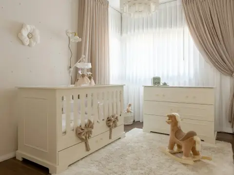 Bebek karyolası ve şifonyer kurulmuş bebek odası